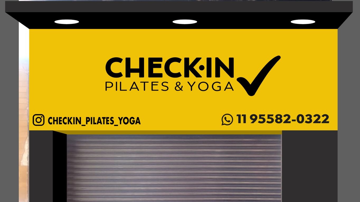 Placa amarela Check-in Pilates & Yoga na fachada da unidade Tatuapé, com o WhatsApp (11) 95582-0322
